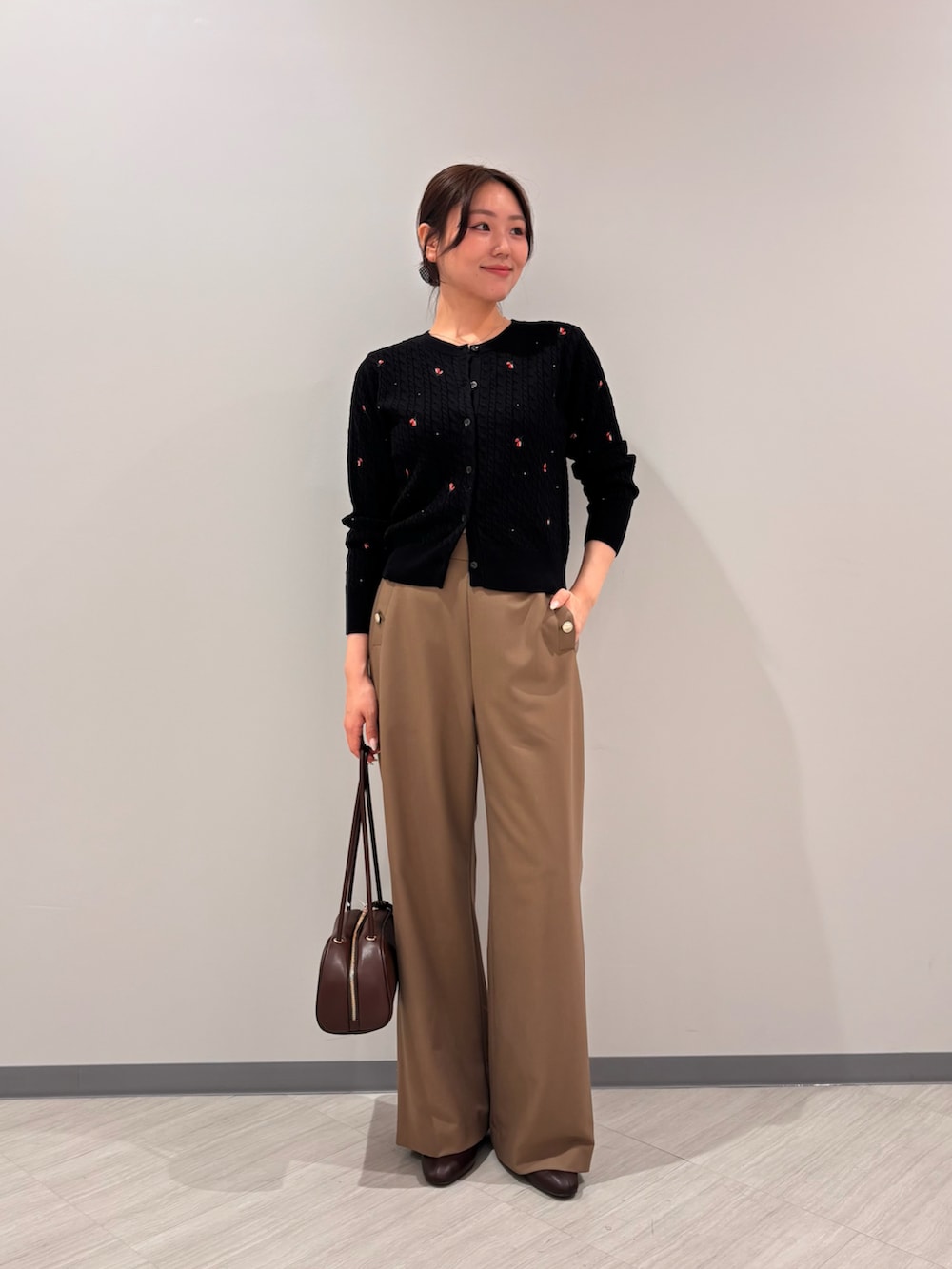 ブラック系のカーディガン/ボレロ、イエロー系のその他パンツ、ブラック系のボストンバッグを着用したレディースの秋コーディネートの3枚目の写真