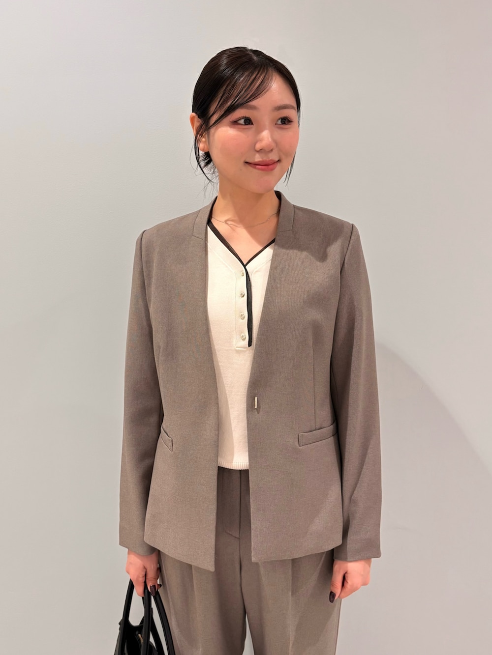 ホワイト系のニット/セーター、ベージュ系のノーカラージャケット、ベージュ系のその他パンツを着用したレディースの秋コーディネートの4枚目の写真