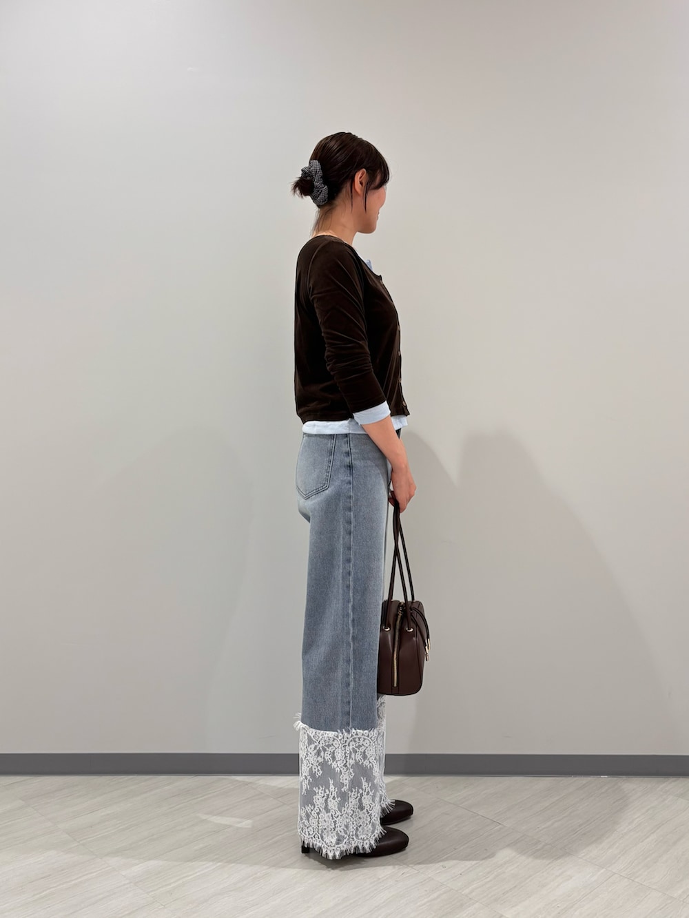 ブラウン系のTシャツ/カットソー、ブルー系のデニムパンツ、ブラック系のボストンバッグを着用したレディースの秋コーディネートの3枚目の写真