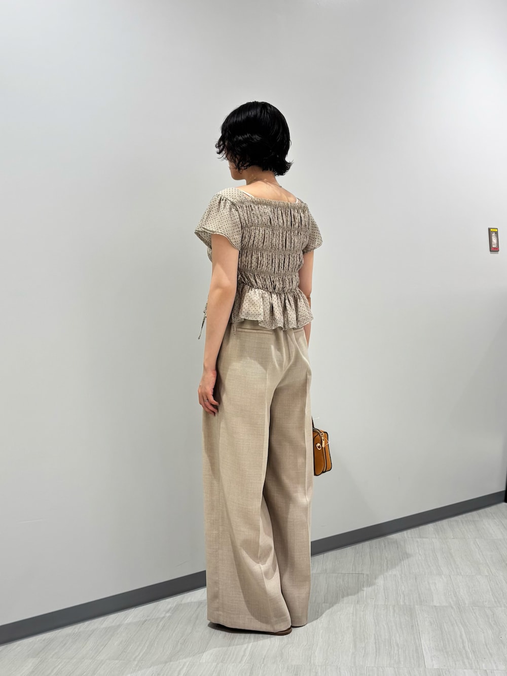 ベージュ系のシャツ/ブラウス、ベージュ系のその他パンツ、オレンジ系のボストンバッグを着用したレディースの夏コーディネートの3枚目の写真