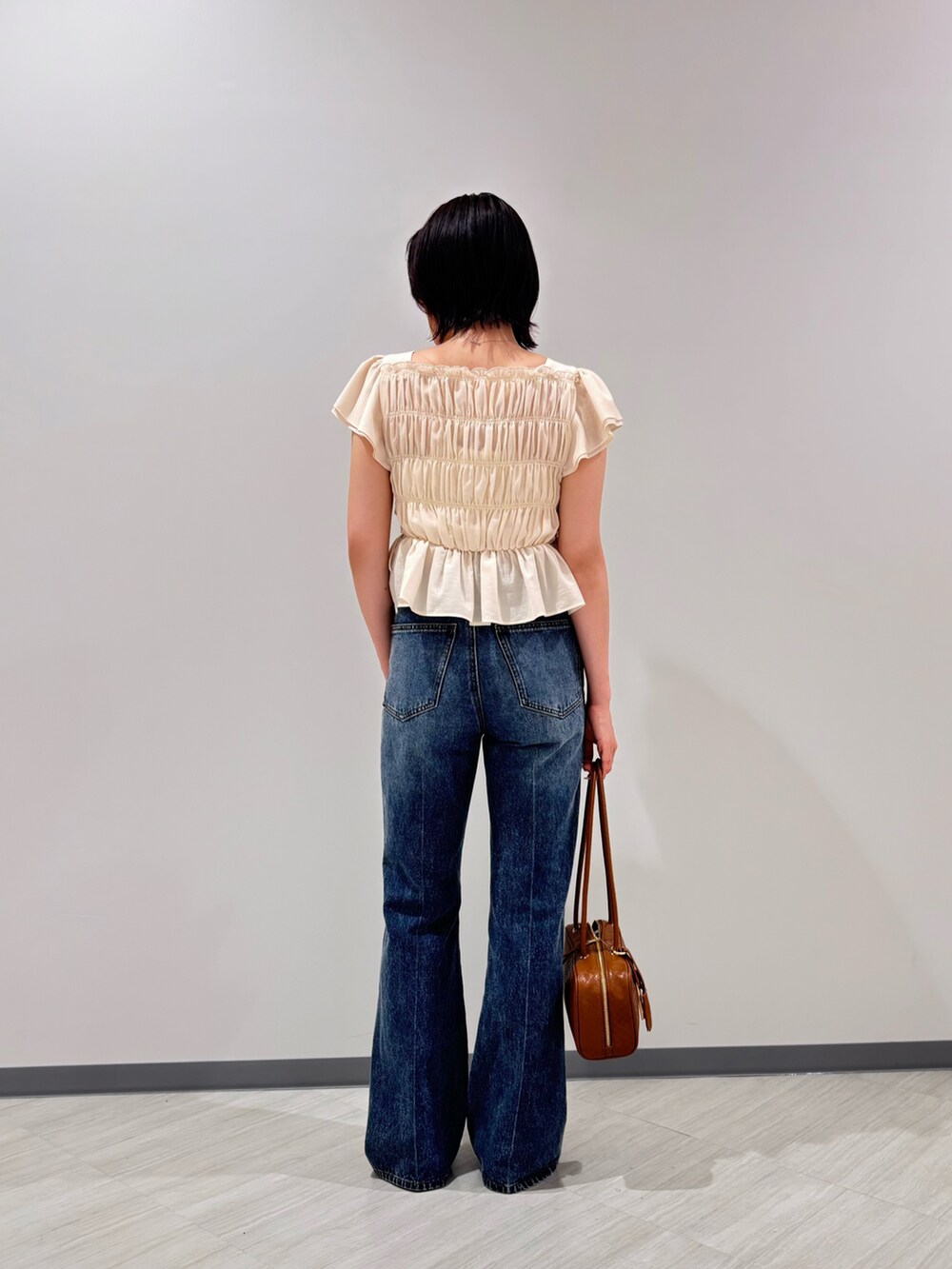 ホワイト系のシャツ/ブラウス、ブルー系のデニムパンツ、オレンジ系のボストンバッグを着用したレディースの夏コーディネートの3枚目の写真