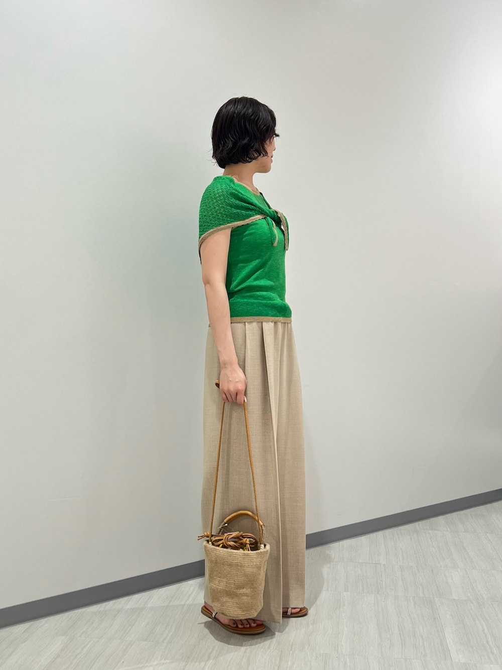 グリーン系のニット/セーター、ベージュ系のパンツ、ベージュ系のショルダーバッグを着用したレディースの夏コーディネートの5枚目の写真
