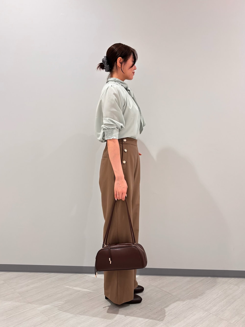 グリーン系のシャツ/ブラウス、イエロー系のその他パンツ、ブラック系のボストンバッグを着用したレディースの秋コーディネートの3枚目の写真