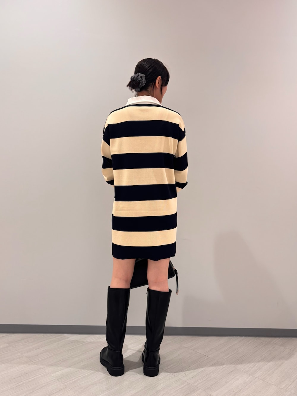 ブルー系のワンピース、ブラック系のボストンバッグ、ブラック系のブーツを着用したレディースの夏コーディネートの4枚目の写真