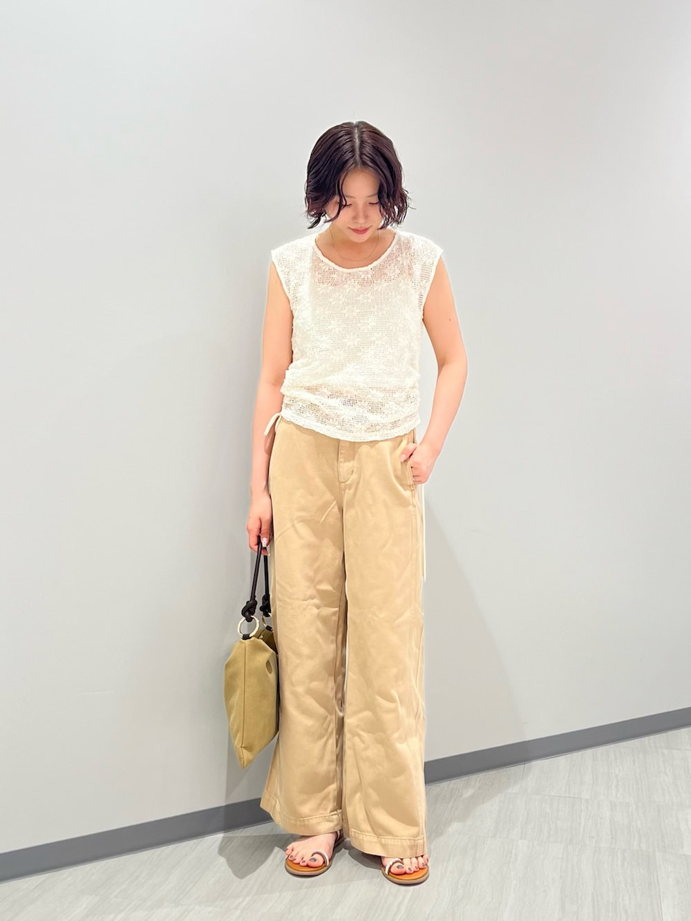ホワイト系のTシャツ/カットソー、ベージュ系のパンツ、ベージュ系のショルダーバッグを着用したレディースの夏コーディネートの3枚目の写真
