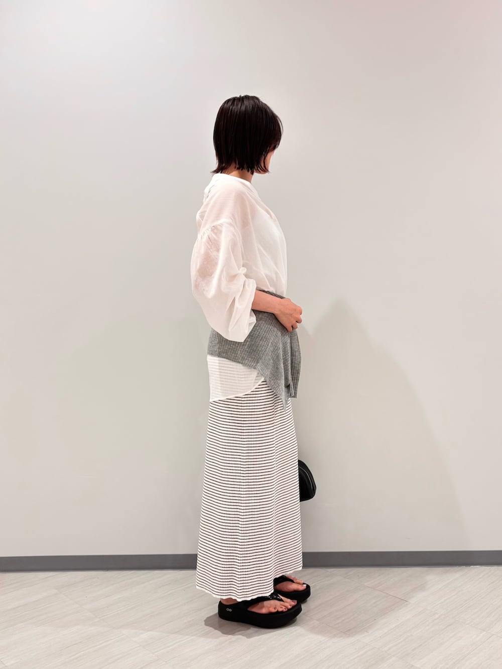 ホワイト系のシャツ/ブラウス、ホワイト系のワンピース、ブラック系のサンダルを着用したレディースの夏コーディネートの3枚目の写真