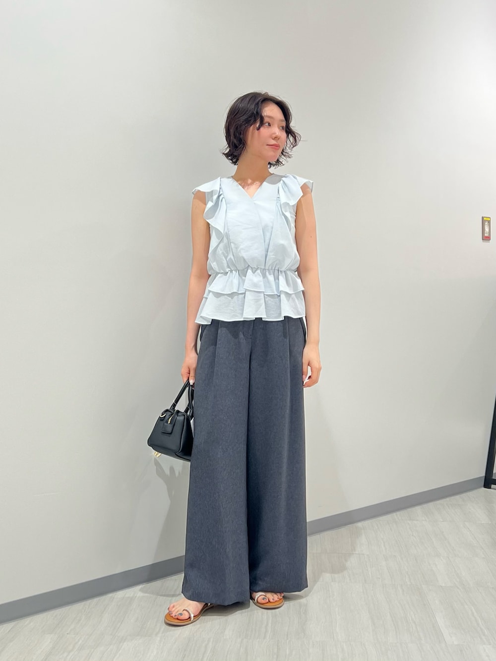 ブルー系のシャツ/ブラウス、ブルー系のその他パンツ、ブラック系のボストンバッグを着用したレディースの夏コーディネートの2枚目の写真