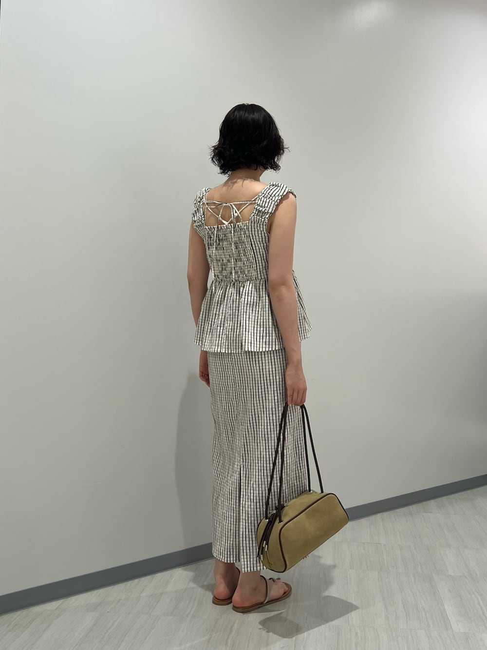 ホワイト系のシャツ/ブラウス、ホワイト系のワンピース、ベージュ系のボストンバッグを着用したレディースの夏コーディネートの4枚目の写真