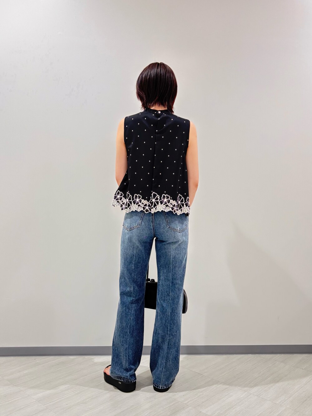 ブラック系のボストンバッグ、ブラック系のシャツ/ブラウス、ブラック系のサンダルを着用したレディースの夏コーディネートの4枚目の写真