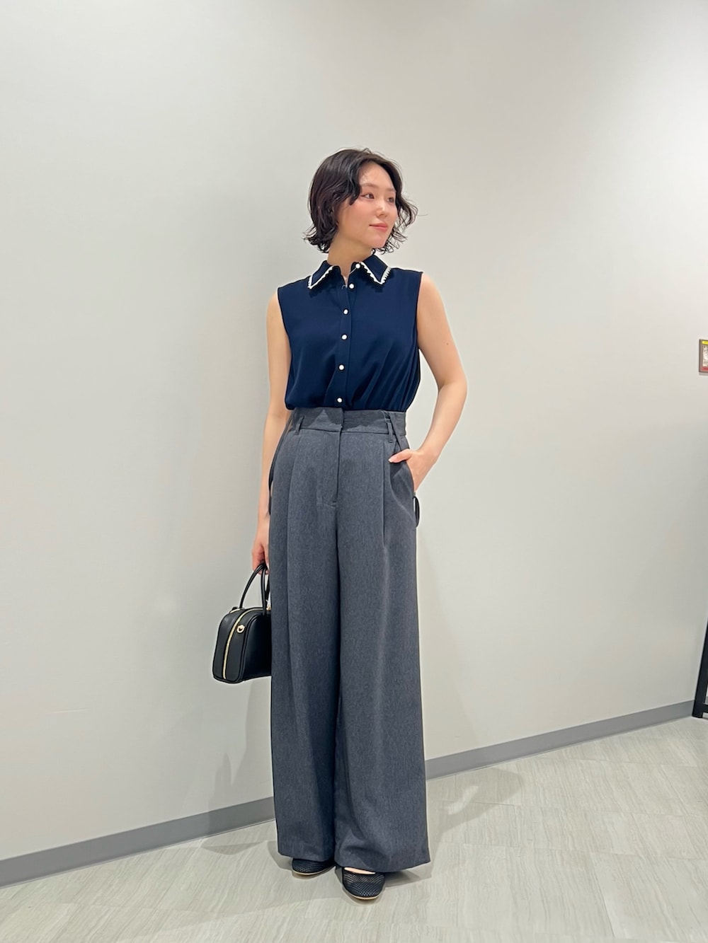 ブルー系のシャツ/ブラウス、ブルー系のその他パンツ、ブラック系のボストンバッグを着用したレディースの夏コーディネートの2枚目の写真