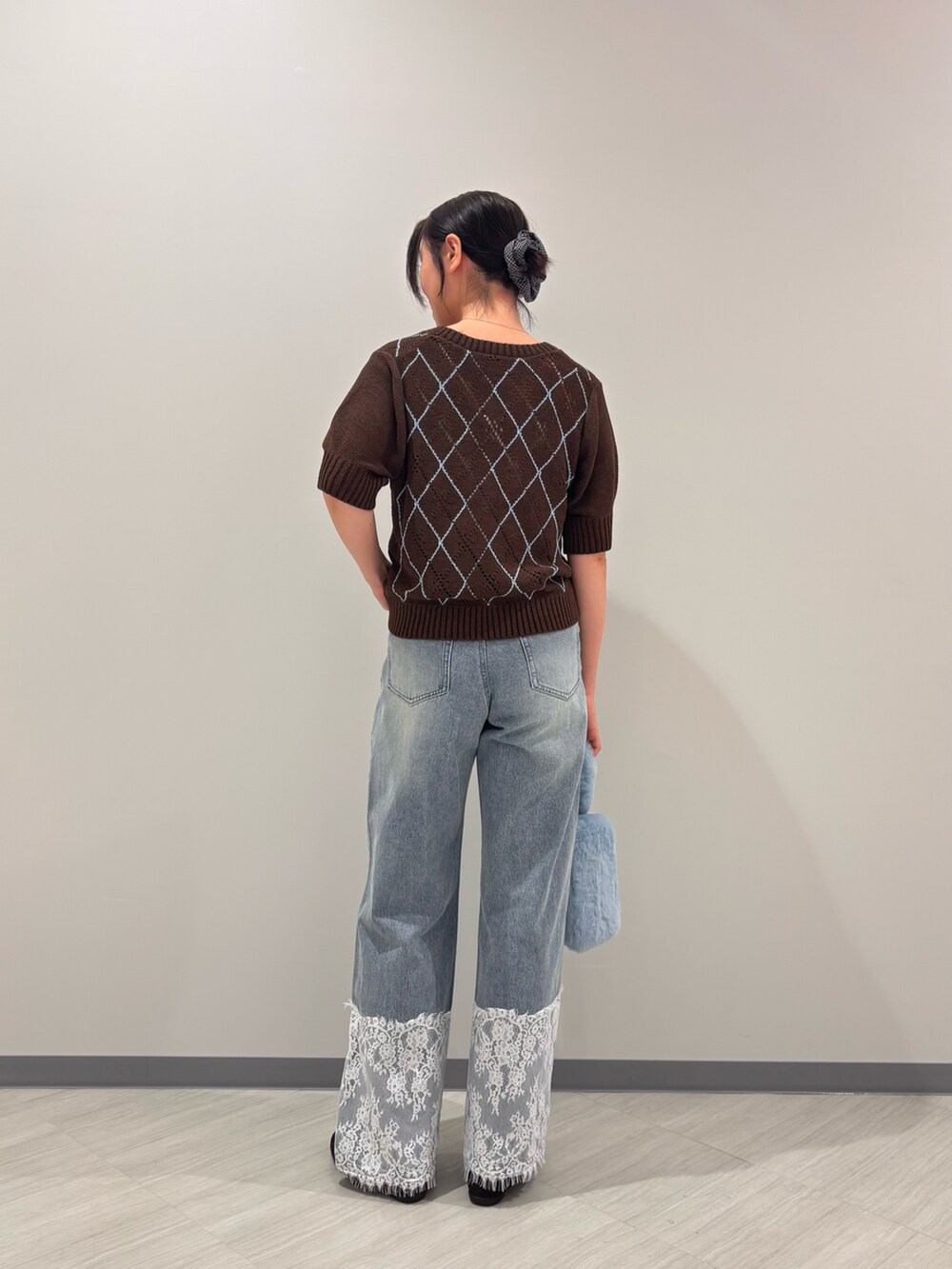 ブラウン系のニット/セーター、ブルー系のデニムパンツ、ブラウン系のバレエシューズを着用したレディースの夏コーディネートの5枚目の写真