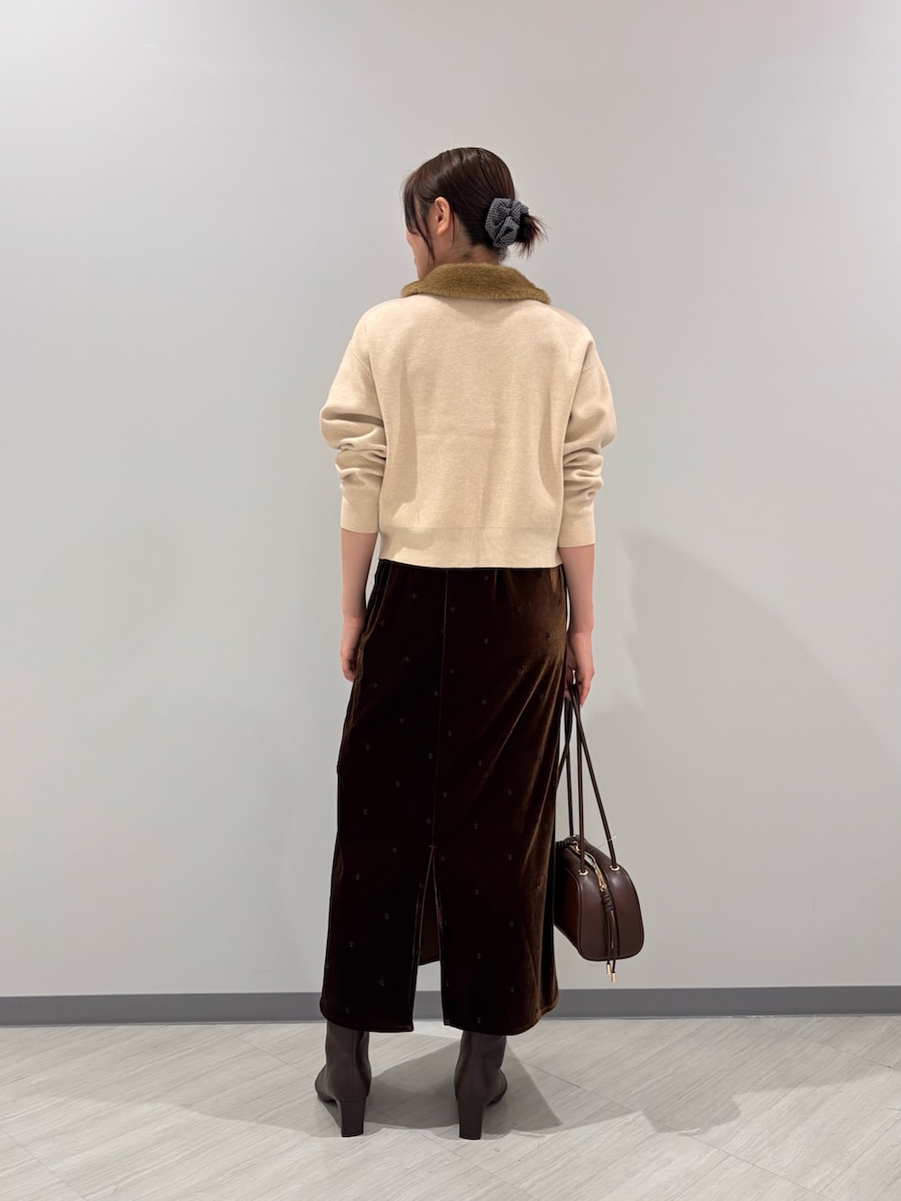 イエロー系のカーディガン/ボレロ、ブラウン系のワンピース、ブラック系のボストンバッグを着用したレディースの秋コーディネートの3枚目の写真