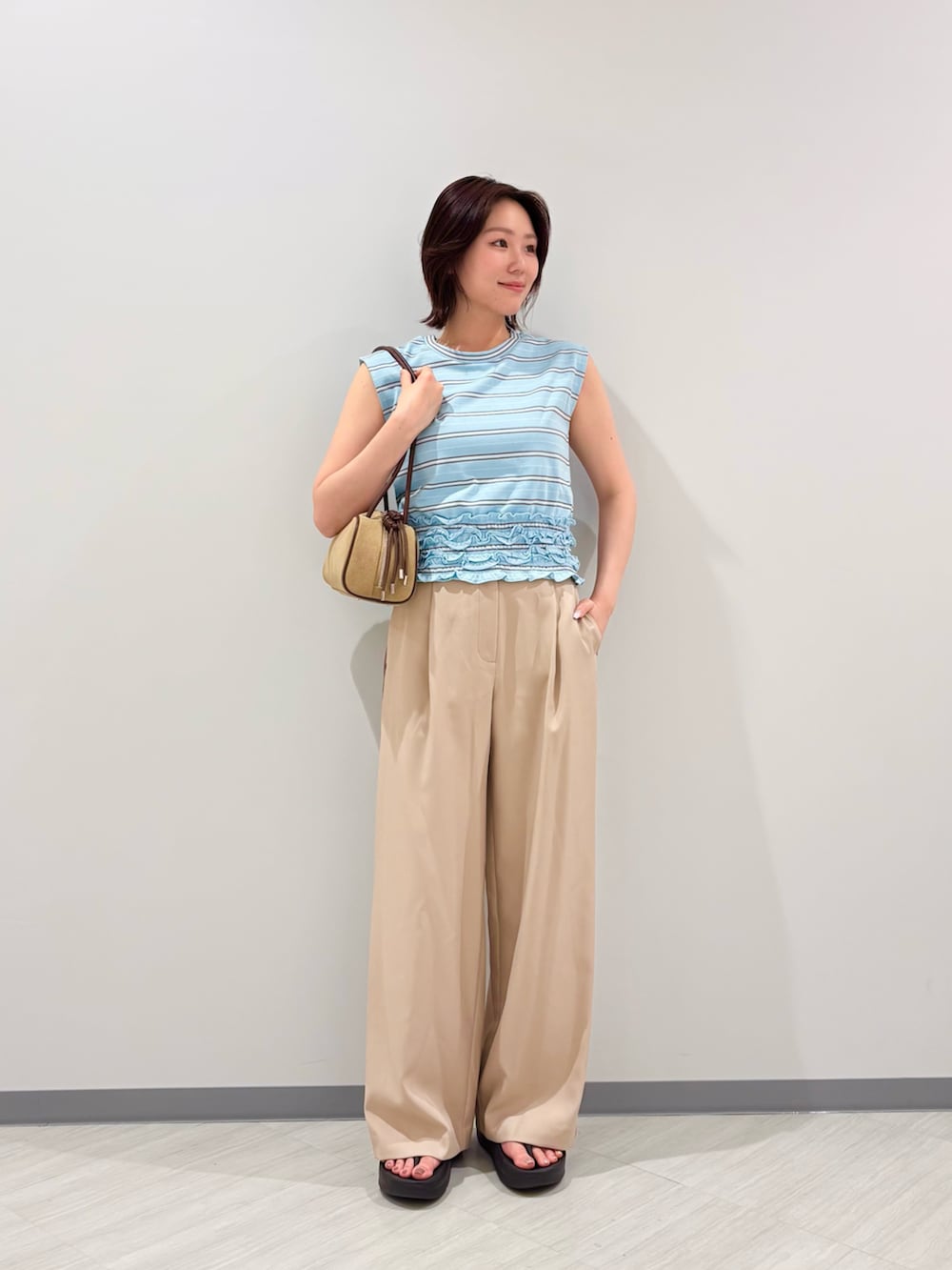 ブルー系のTシャツ/カットソー、ベージュ系のその他パンツ、ベージュ系のボストンバッグを着用したレディースの夏コーディネートの2枚目の写真