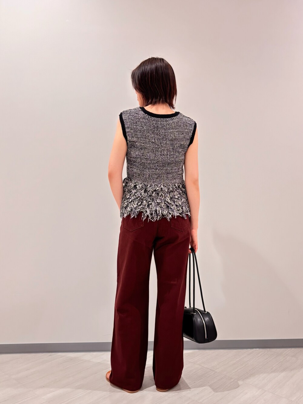 ブラック系のニット/セーター、ブラウン系のその他パンツ、イエロー系のサンダルを着用したレディースの夏コーディネートの4枚目の写真