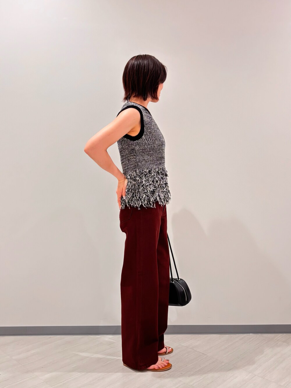 ブラック系のニット/セーター、ブラウン系のその他パンツ、イエロー系のサンダルを着用したレディースの夏コーディネートの3枚目の写真
