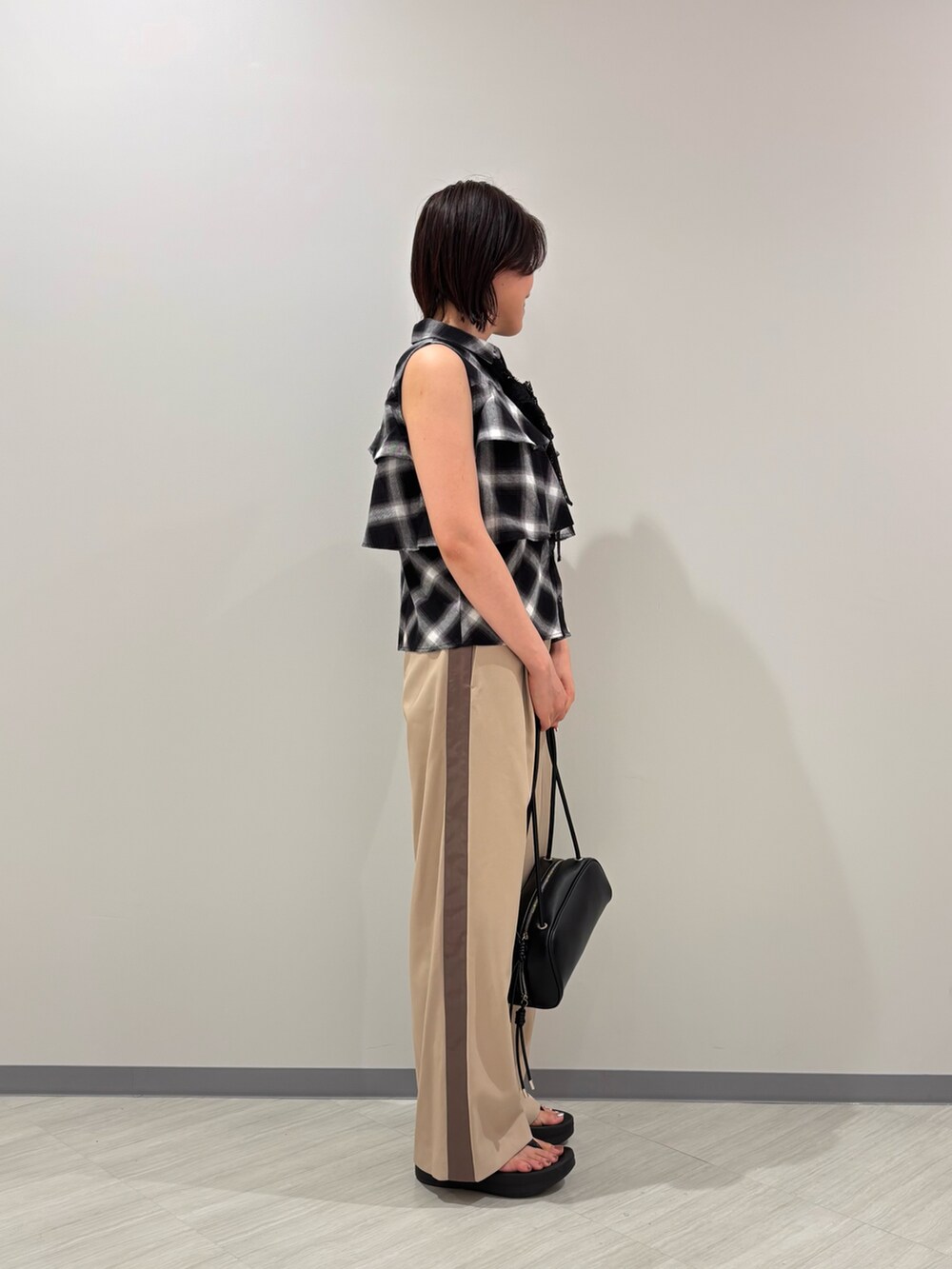 ブラック系のシャツ/ブラウス、ベージュ系のその他パンツ、ブラック系のボストンバッグを着用したレディースの夏コーディネートの4枚目の写真