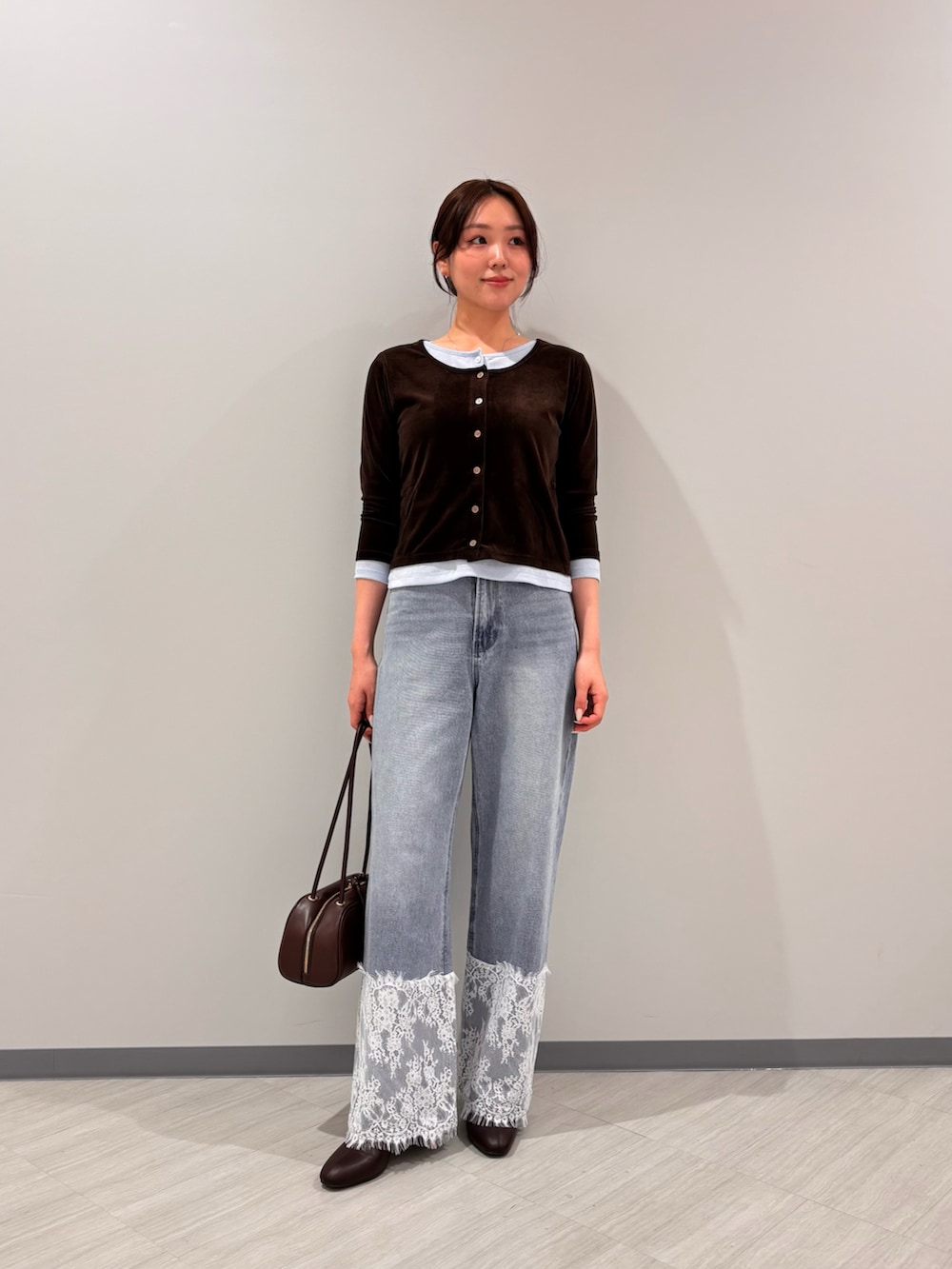 ブラウン系のTシャツ/カットソー、ブルー系のデニムパンツ、ブラック系のボストンバッグを着用したレディースの秋コーディネートの2枚目の写真
