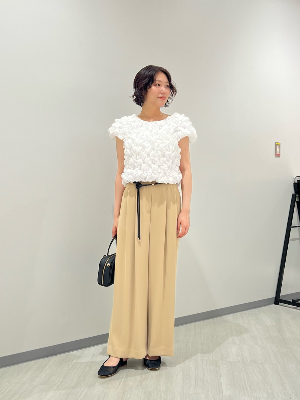 ホワイト系のシャツ/ブラウス、イエロー系のその他パンツ、ブラック系のボストンバッグを着用したレディースの夏コーディネートの2枚目の写真