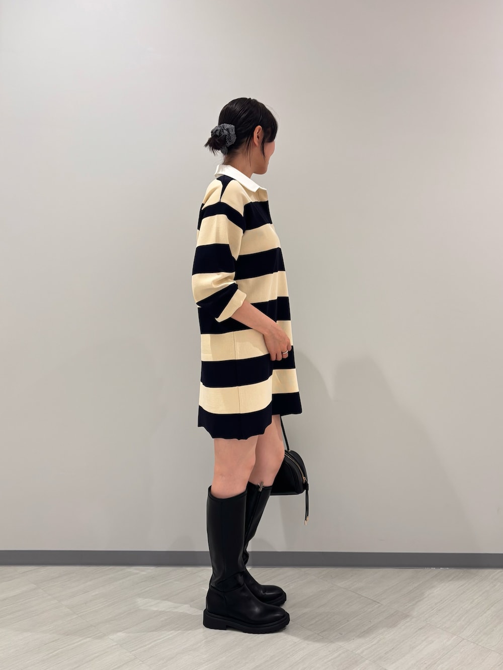 ブルー系のワンピース、ブラック系のボストンバッグ、ブラック系のブーツを着用したレディースの夏コーディネートの3枚目の写真
