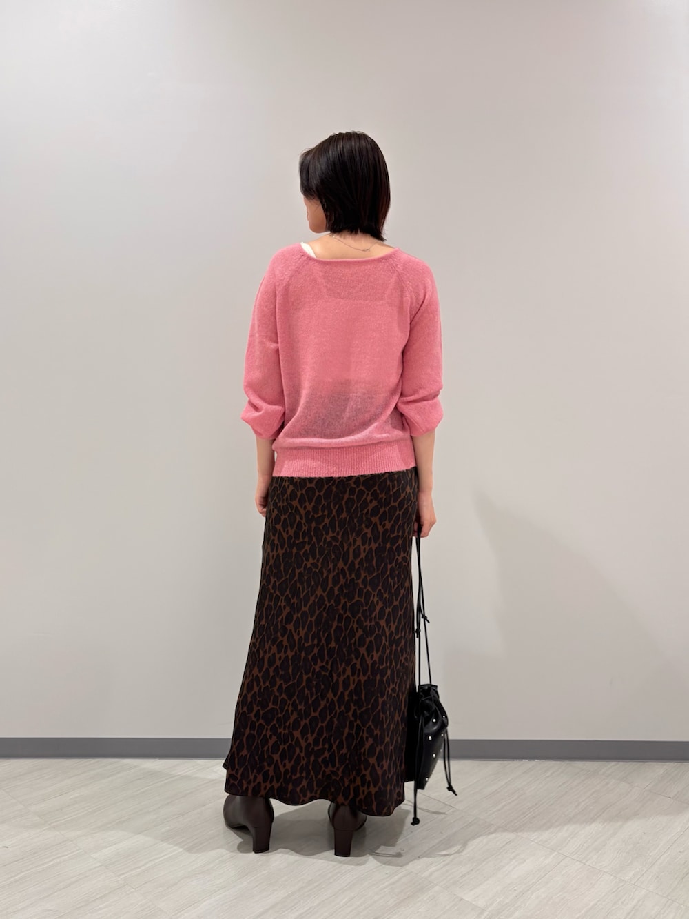 ピンク系のニット/セーター、ブラウン系のスカート、ブラウン系のブーツを着用したレディースの秋コーディネートの3枚目の写真