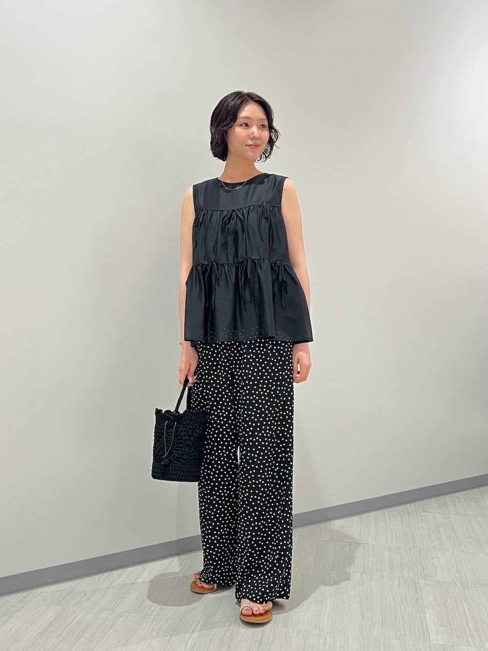 ブラック系のその他パンツ、ブラック系のハンドバッグ、イエロー系のサンダルを着用したレディースの夏コーディネートの2枚目の写真