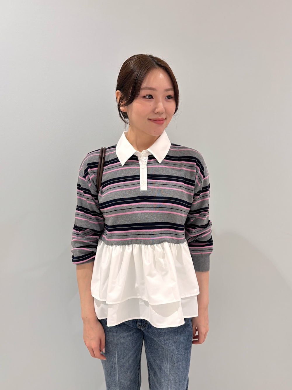 グレー系のニット/セーター、ブラウン系のブーツ、ブラック系のボストンバッグを着用したレディースの秋コーディネートの4枚目の写真