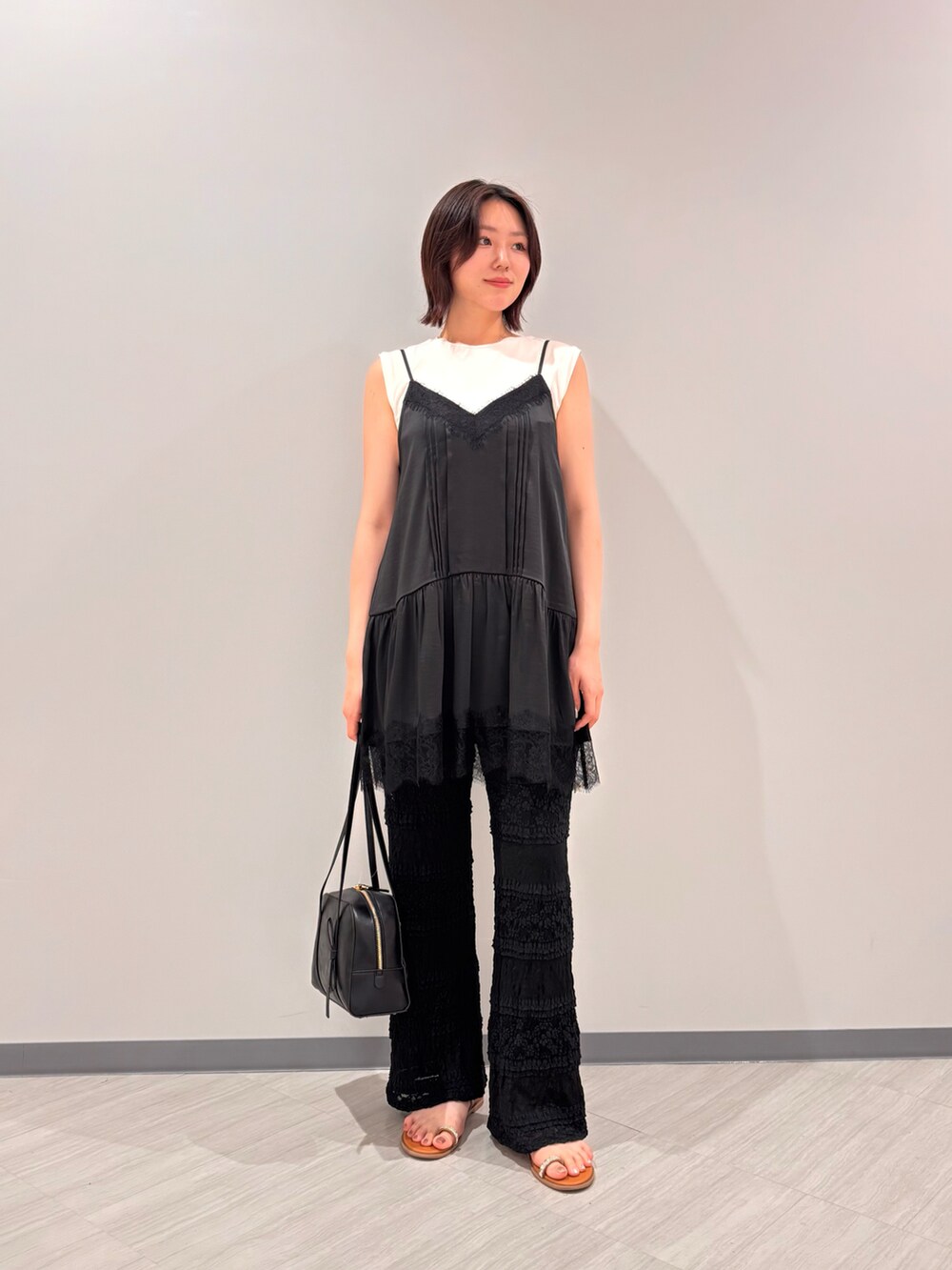 ブラック系のキャミソール、ブラック系のその他パンツ、イエロー系のサンダルを着用したレディースの夏コーディネートの2枚目の写真