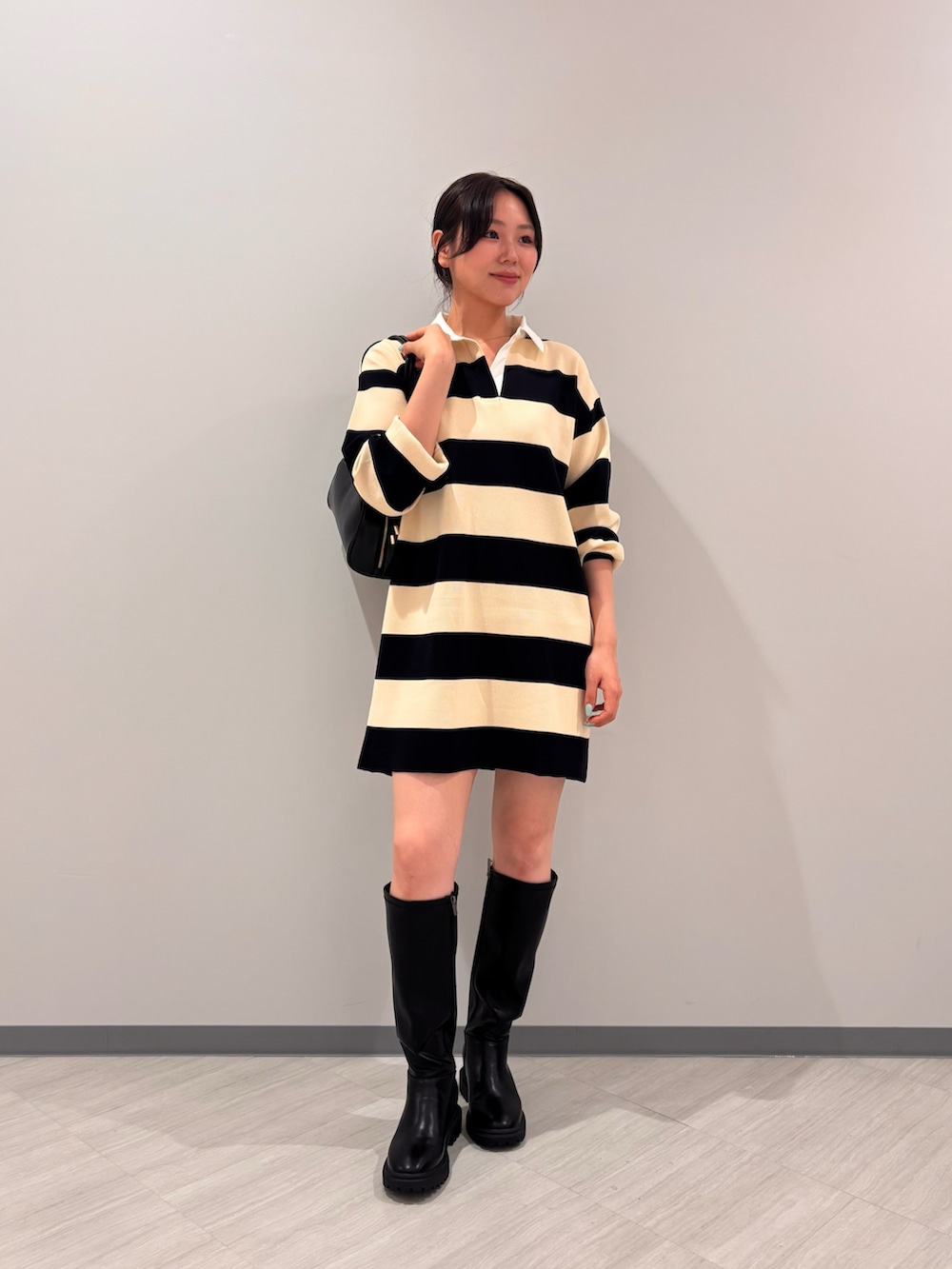 ブルー系のワンピース、ブラック系のボストンバッグ、ブラック系のブーツを着用したレディースの夏コーディネートの2枚目の写真