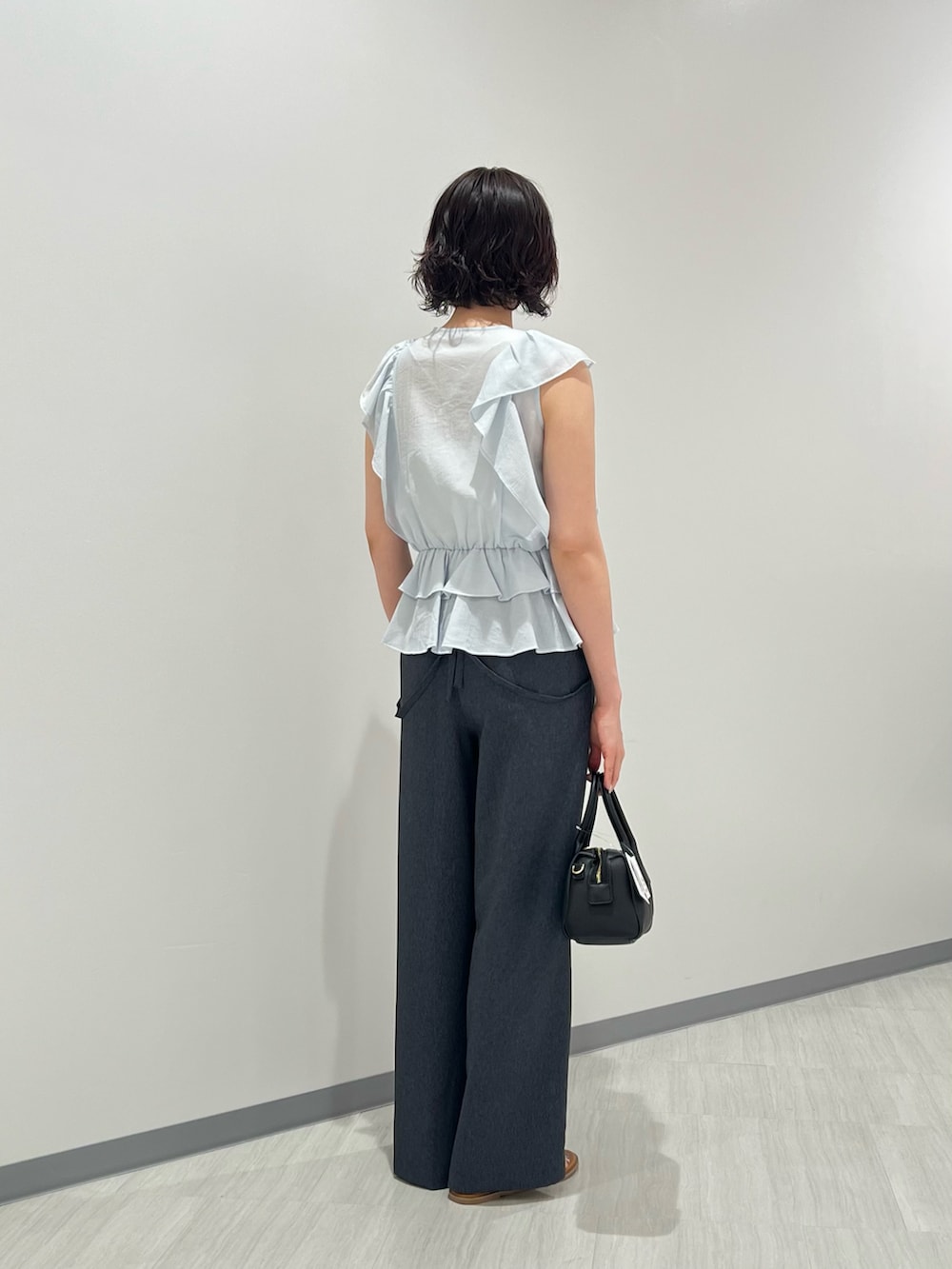 ブルー系のシャツ/ブラウス、ブルー系のその他パンツ、ブラック系のボストンバッグを着用したレディースの夏コーディネートの3枚目の写真