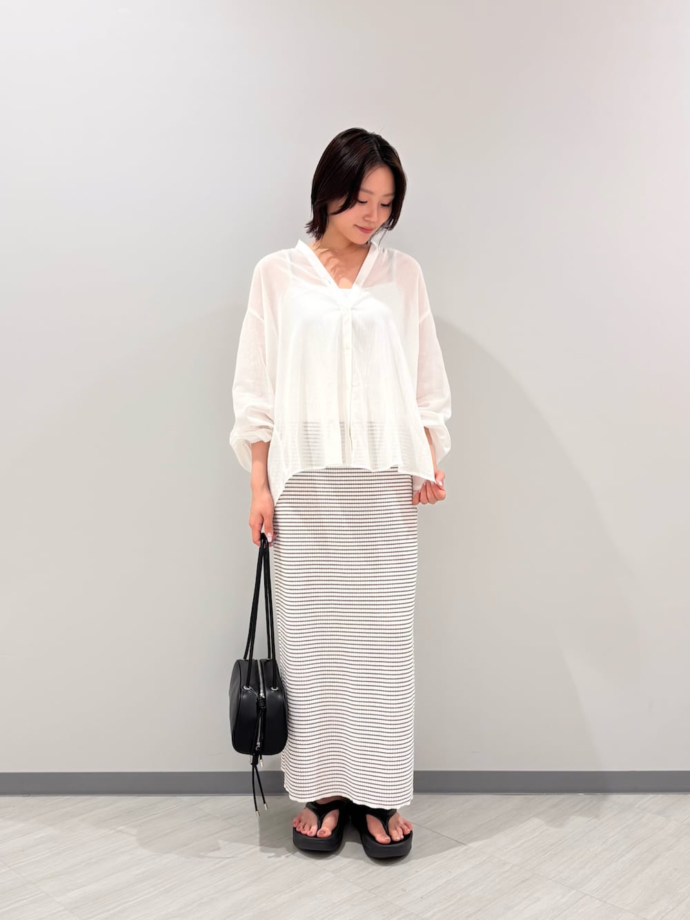 ホワイト系のシャツ/ブラウス、ホワイト系のワンピース、ブラック系のサンダルを着用したレディースの夏コーディネートの5枚目の写真