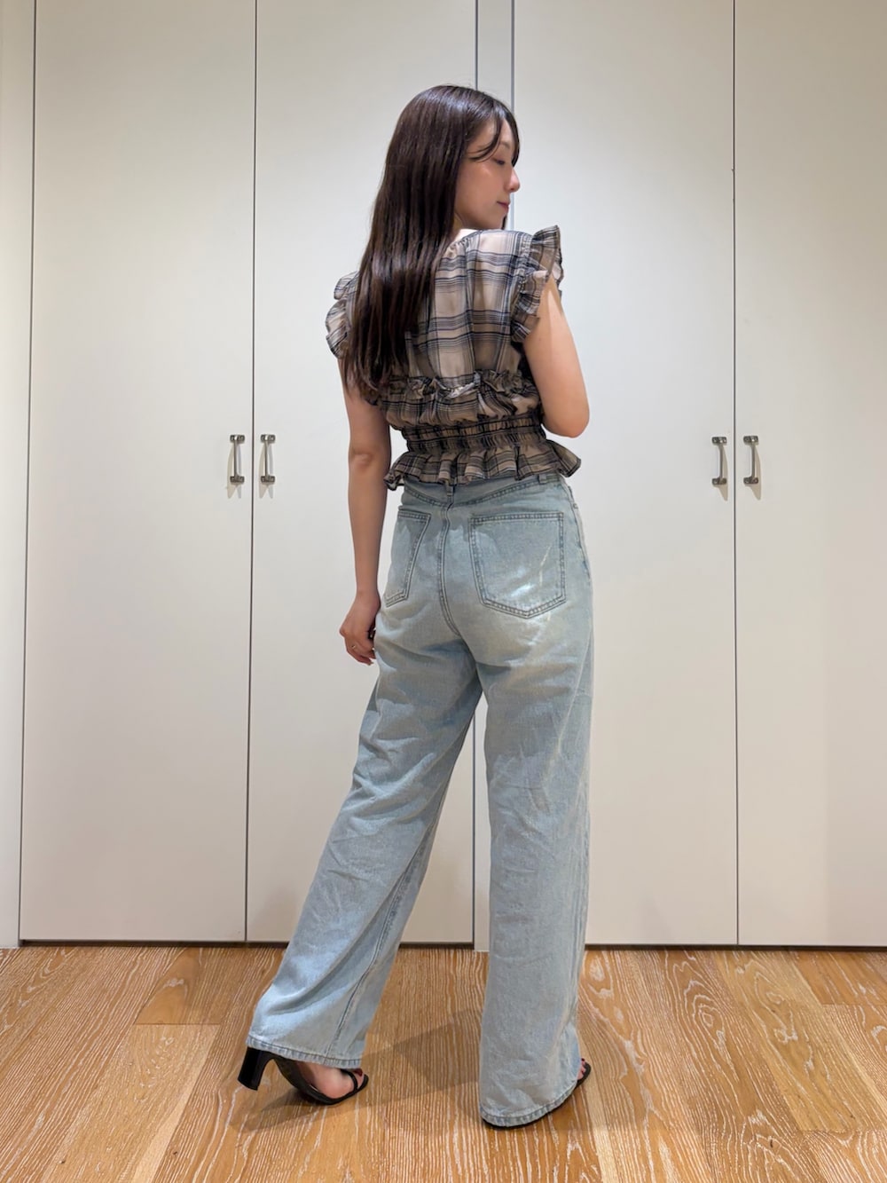 ブルー系のデニムパンツ、ベージュ系のシャツ/ブラウスを着用したレディースの夏コーディネートの2枚目の写真