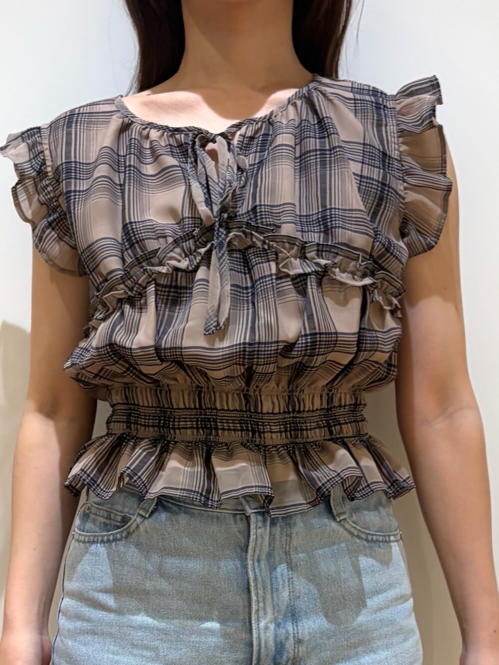 ブルー系のデニムパンツ、ベージュ系のシャツ/ブラウスを着用したレディースの夏コーディネートの4枚目の写真