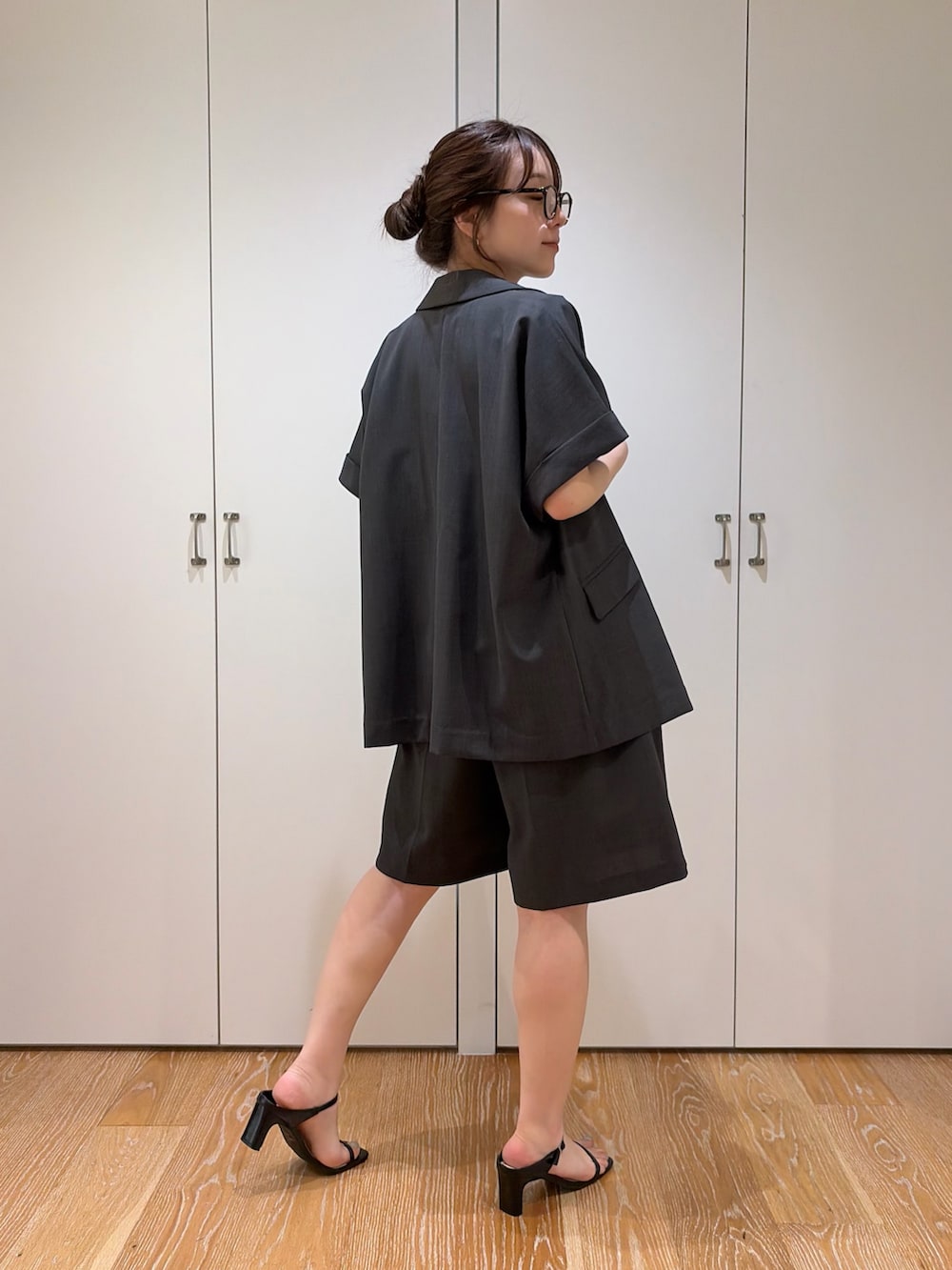 グレー系のその他パンツ、グレー系のテーラードジャケット、ブラウン系のタンクトップを着用したレディースの夏コーディネートの2枚目の写真
