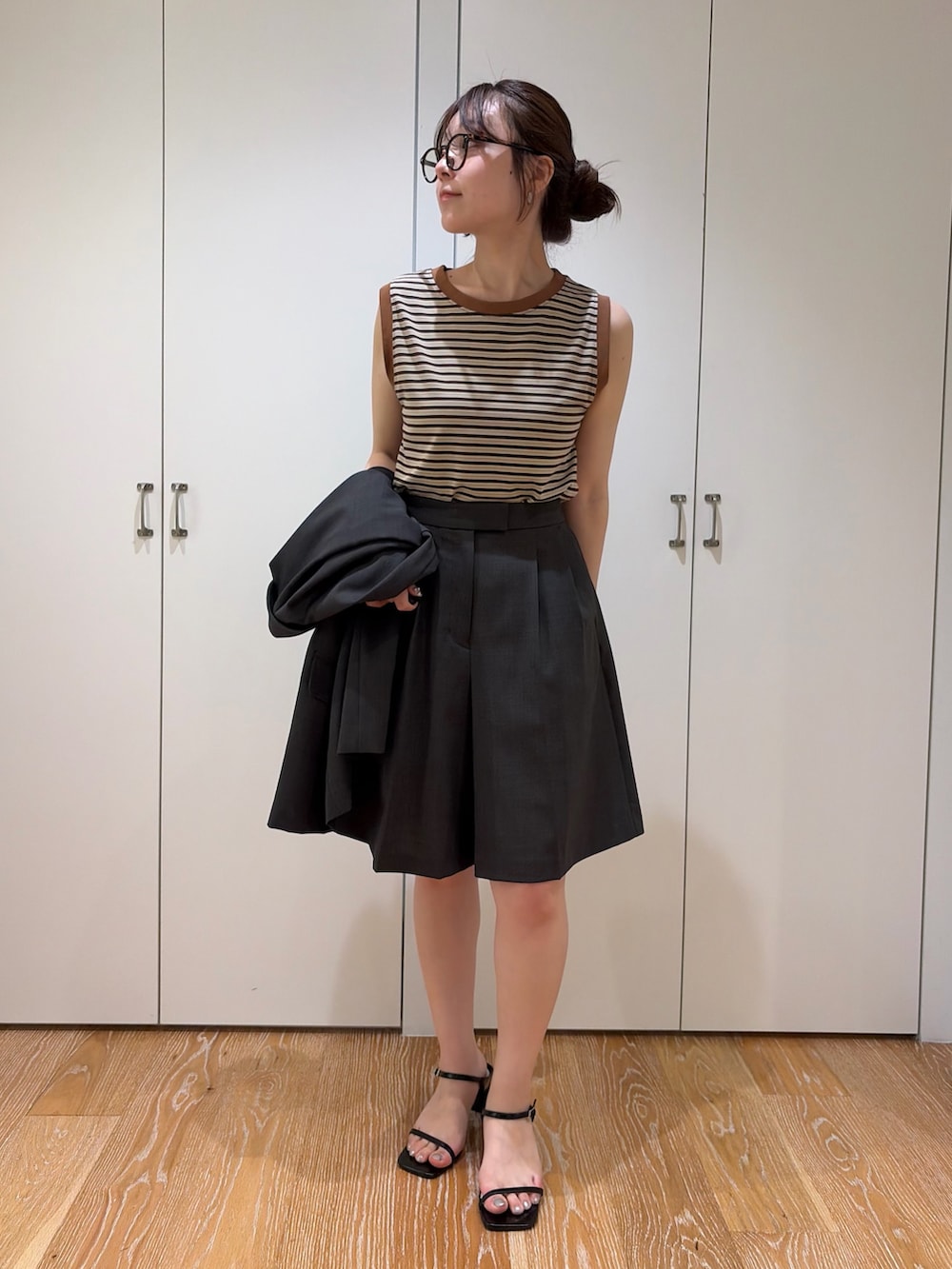 グレー系のその他パンツ、グレー系のテーラードジャケット、ブラウン系のタンクトップを着用したレディースの夏コーディネートの3枚目の写真