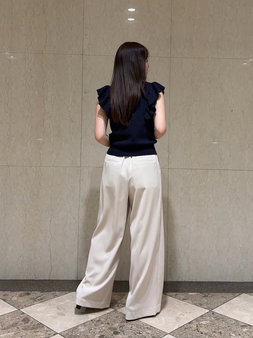 ブルー系のニット/セーター、ベージュ系のその他パンツ、ブラック系のサンダルを着用したレディースの夏コーディネートの2枚目の写真