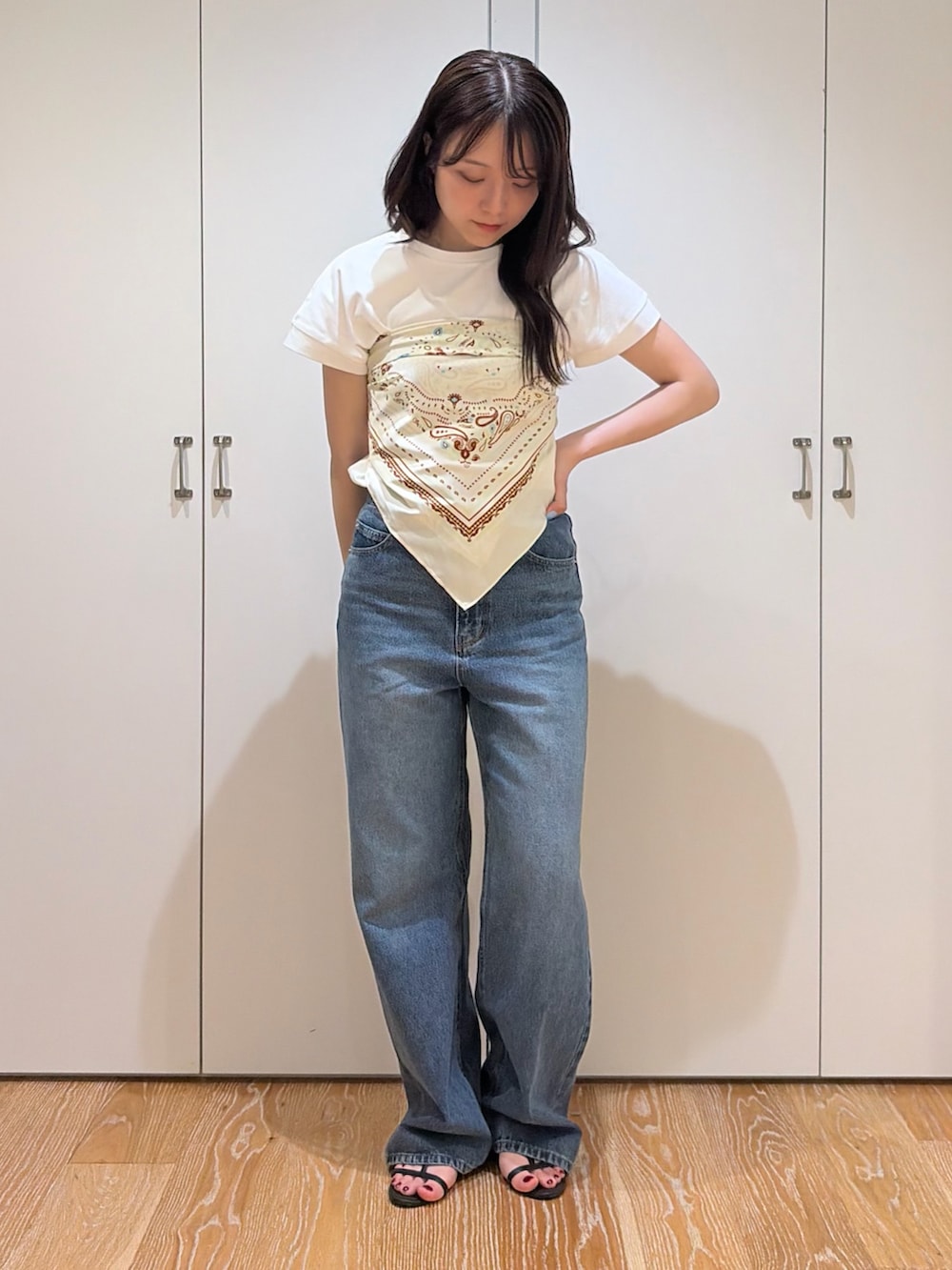 ブルー系のデニムパンツ、ホワイト系のTシャツ/カットソー、ベージュ系のバンダナ/スカーフを着用したレディースの夏コーディネートの5枚目の写真