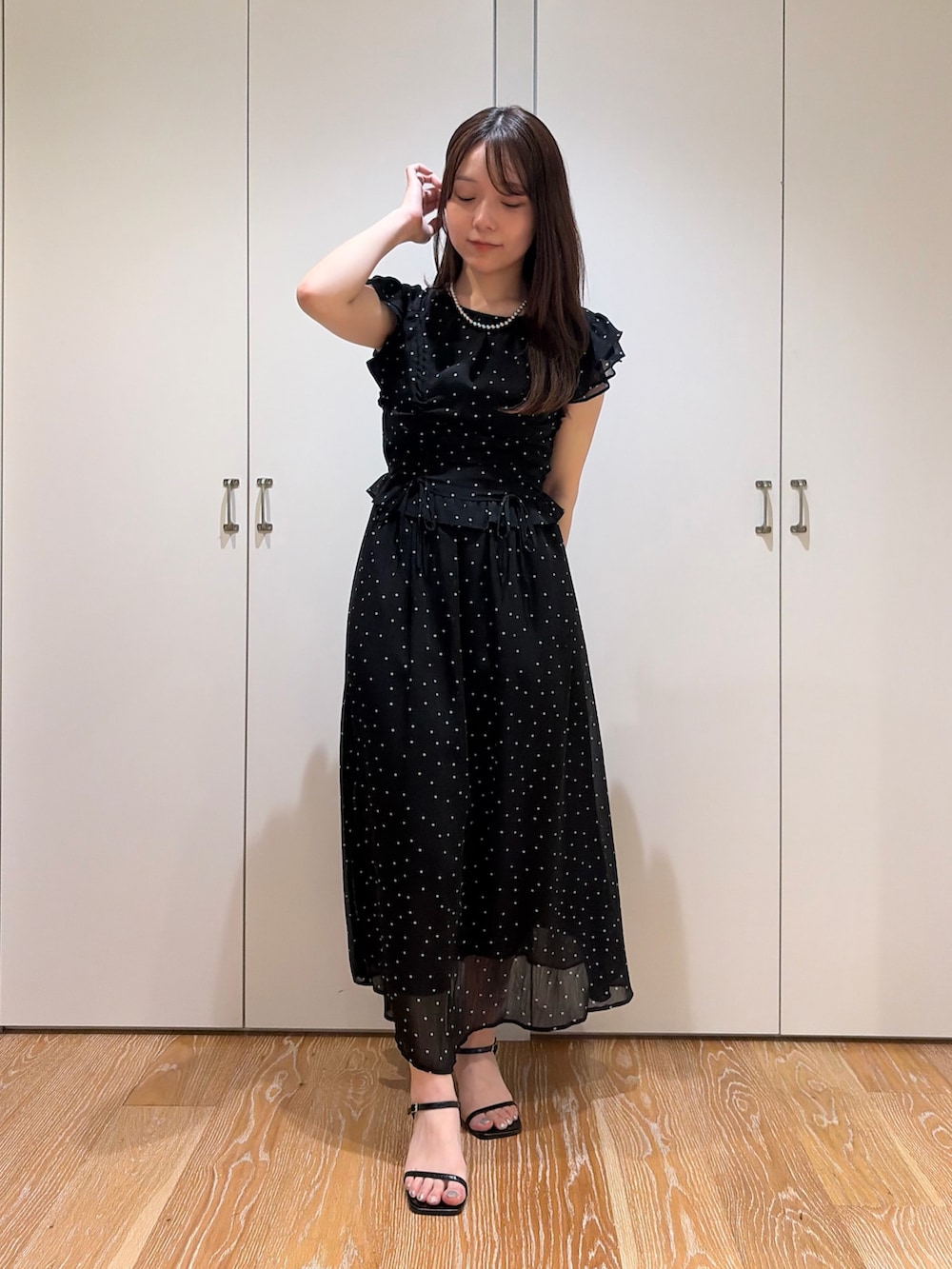 ブラック系のワンピースを着用したレディースの夏コーディネートの2枚目の写真
