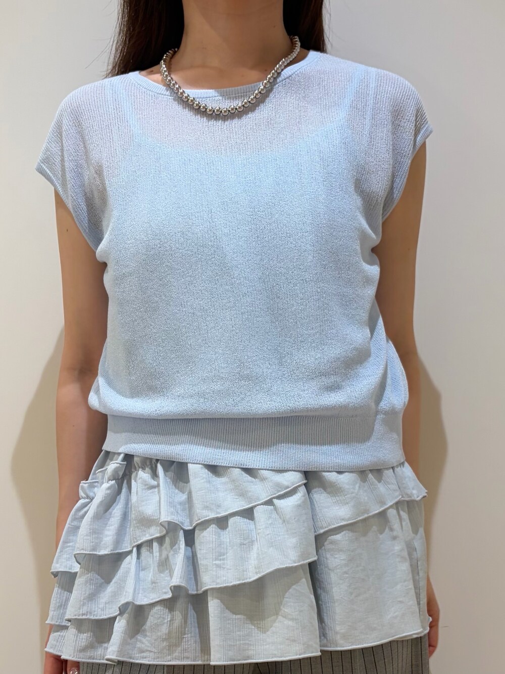 ブルー系のニット/セーター、グレー系のその他パンツを着用したレディースの夏コーディネートの2枚目の写真