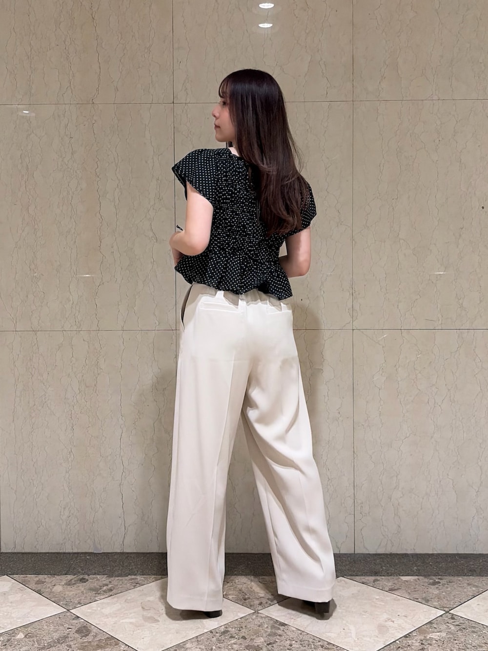 ベージュ系のその他パンツ、ブラック系のシャツ/ブラウス、ブラック系のサンダルを着用したレディースの夏コーディネートの2枚目の写真