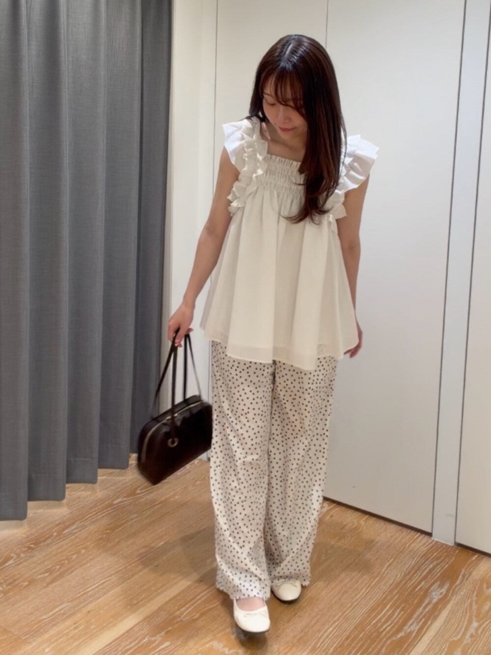 ホワイト系のシャツ/ブラウス、ホワイト系のその他パンツ、ブラウン系のボストンバッグを着用したレディースの夏コーディネートの3枚目の写真