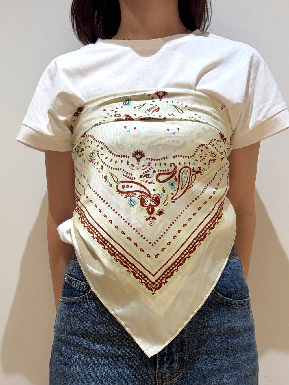 ブルー系のデニムパンツ、ホワイト系のTシャツ/カットソー、ベージュ系のバンダナ/スカーフを着用したレディースの夏コーディネートの6枚目の写真