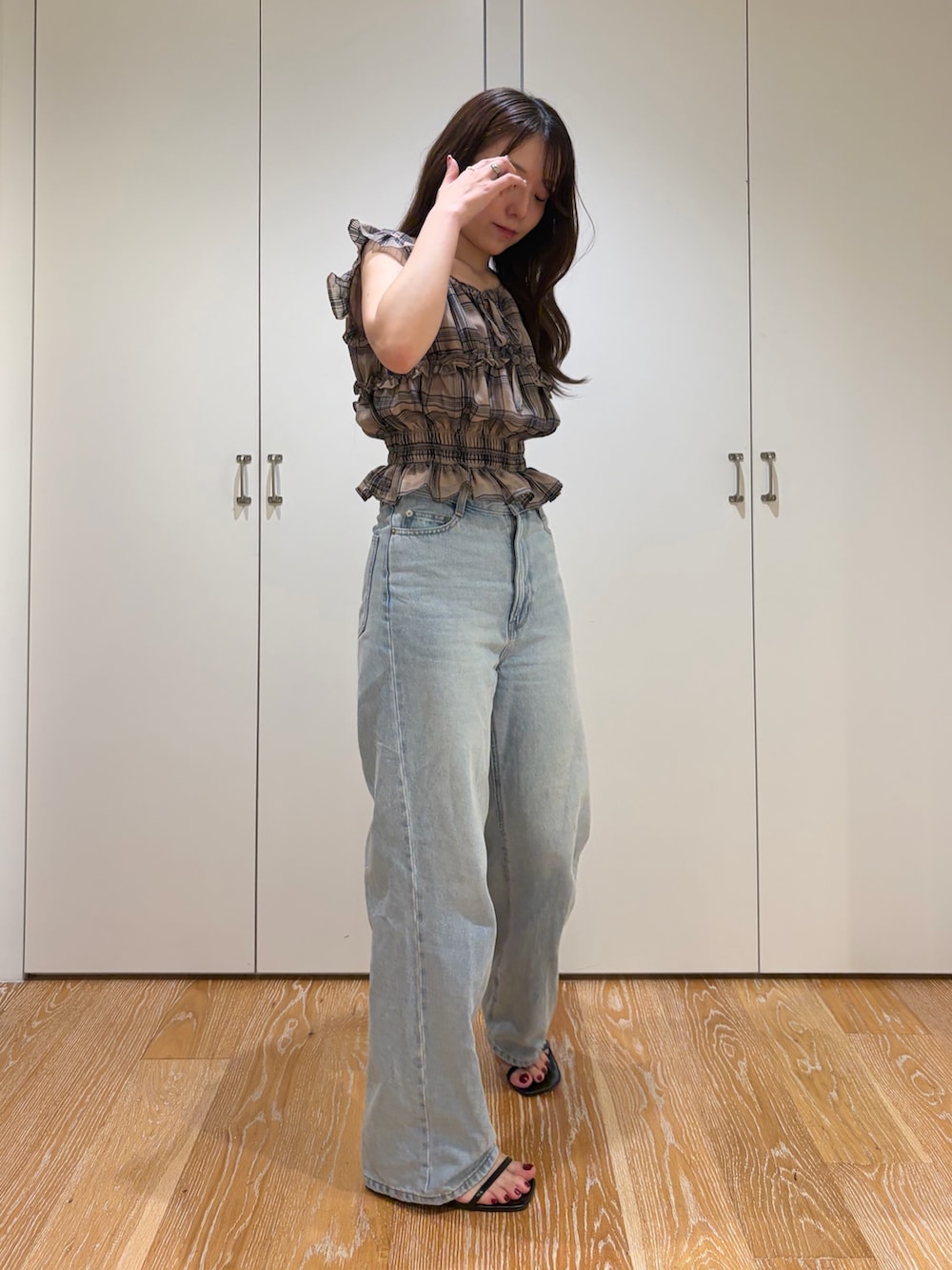 ブルー系のデニムパンツ、ベージュ系のシャツ/ブラウスを着用したレディースの夏コーディネートの3枚目の写真