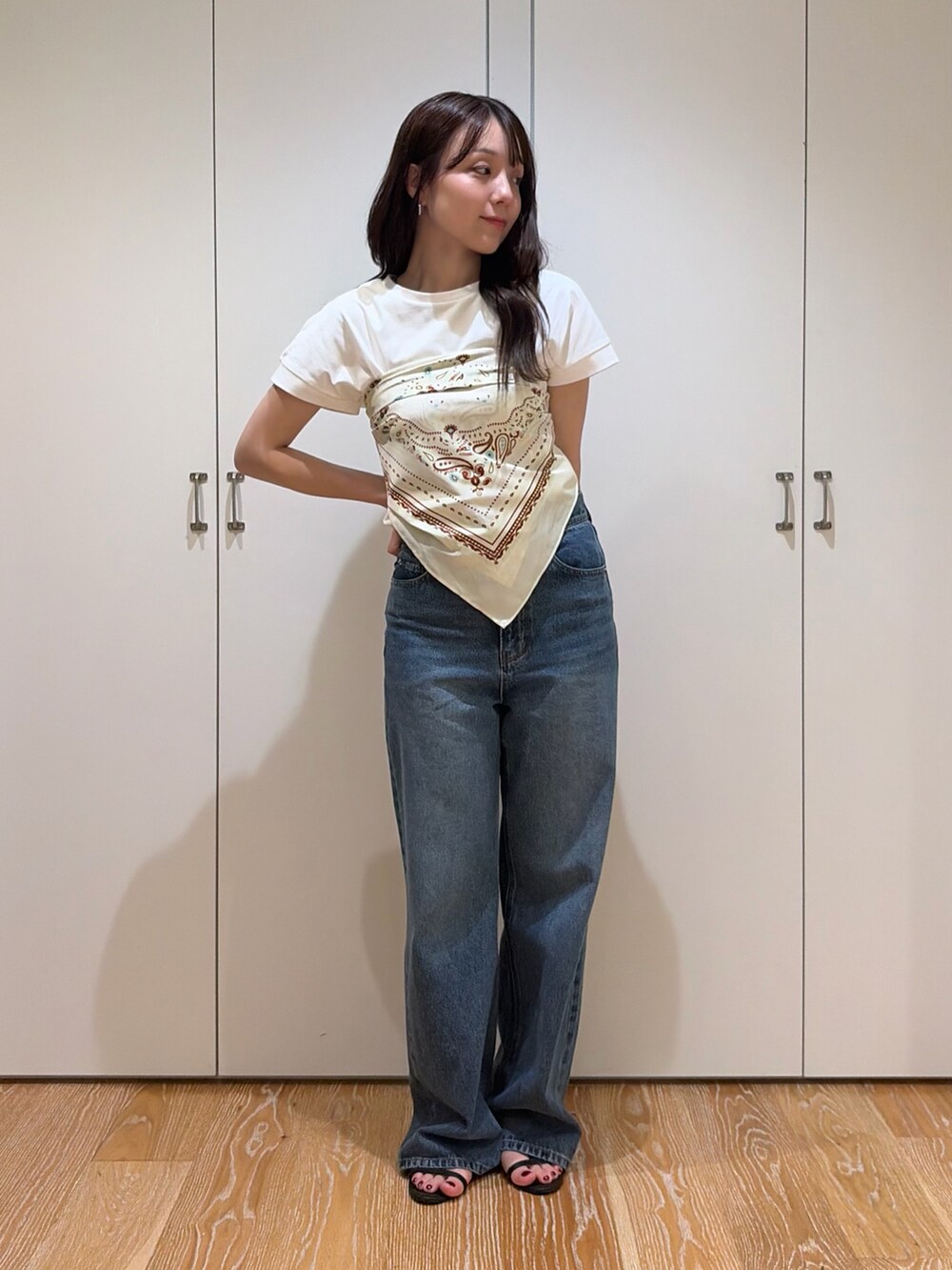 ブルー系のデニムパンツ、ホワイト系のTシャツ/カットソー、ベージュ系のバンダナ/スカーフを着用したレディースの夏コーディネートの4枚目の写真