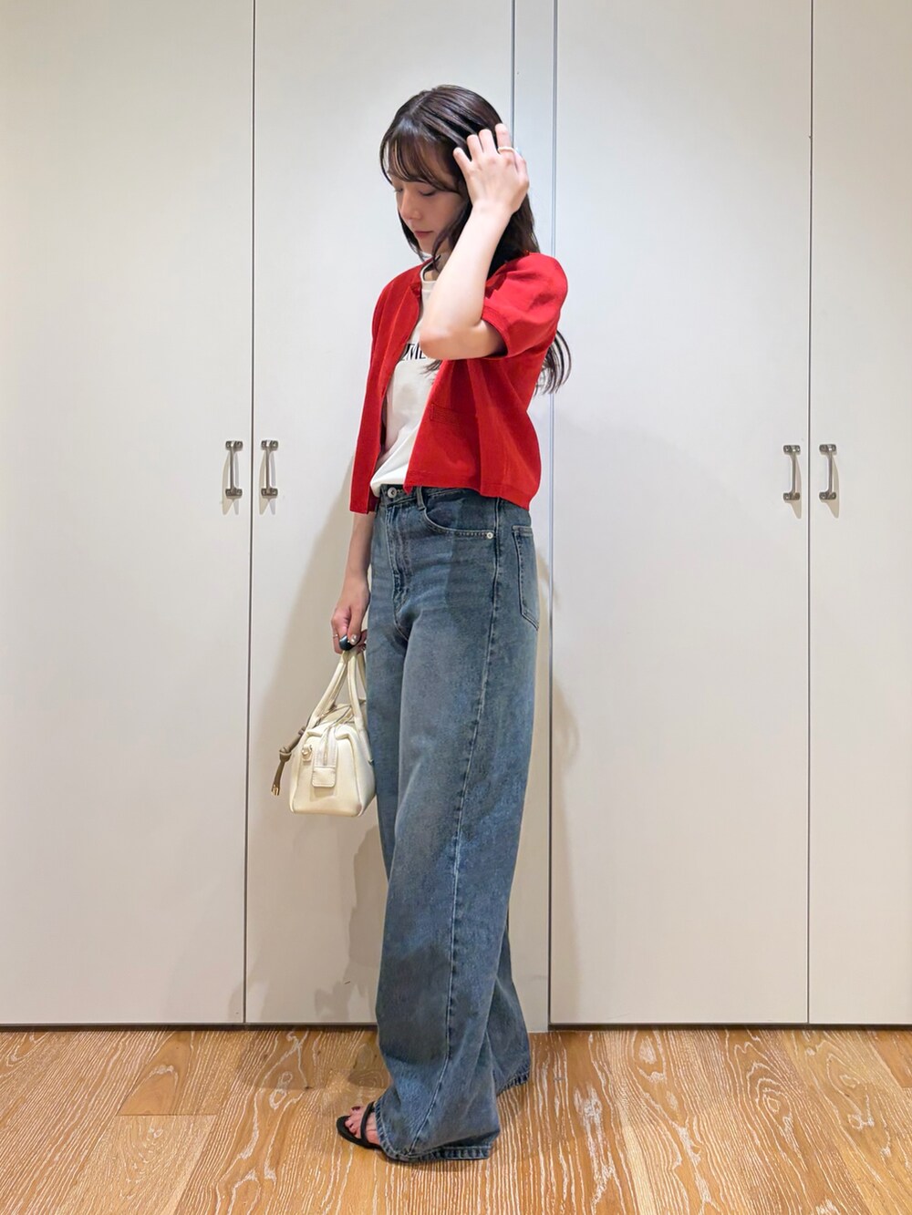 ホワイト系のTシャツ/カットソー、レッド系のカーディガン/ボレロ、ブルー系のデニムパンツを着用したレディースの夏コーディネートの3枚目の写真