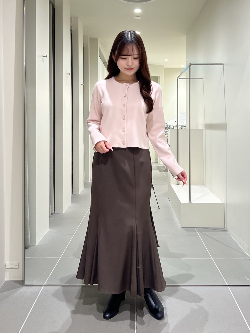 ピンク系のカーディガン/ボレロ、ブラウン系のスカート、ブラック系のブーツを着用したレディースの夏コーディネートの4枚目の写真