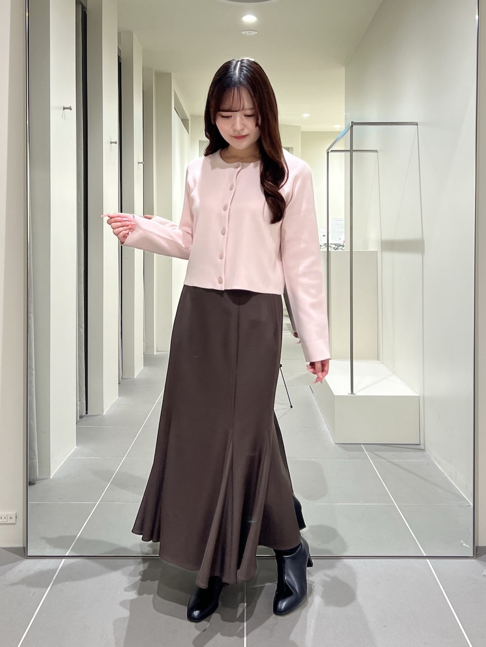 ピンク系のカーディガン/ボレロ、ブラウン系のスカート、ブラック系のブーツを着用したレディースの夏コーディネートの5枚目の写真