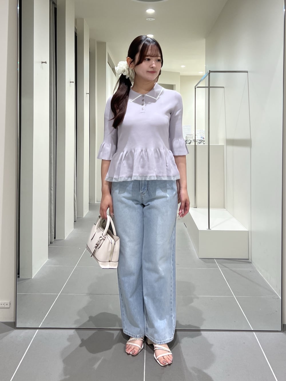 グレー系のニット/セーター、ブルー系のデニムパンツ、ホワイト系のトートバッグを着用したレディースの夏コーディネートの3枚目の写真