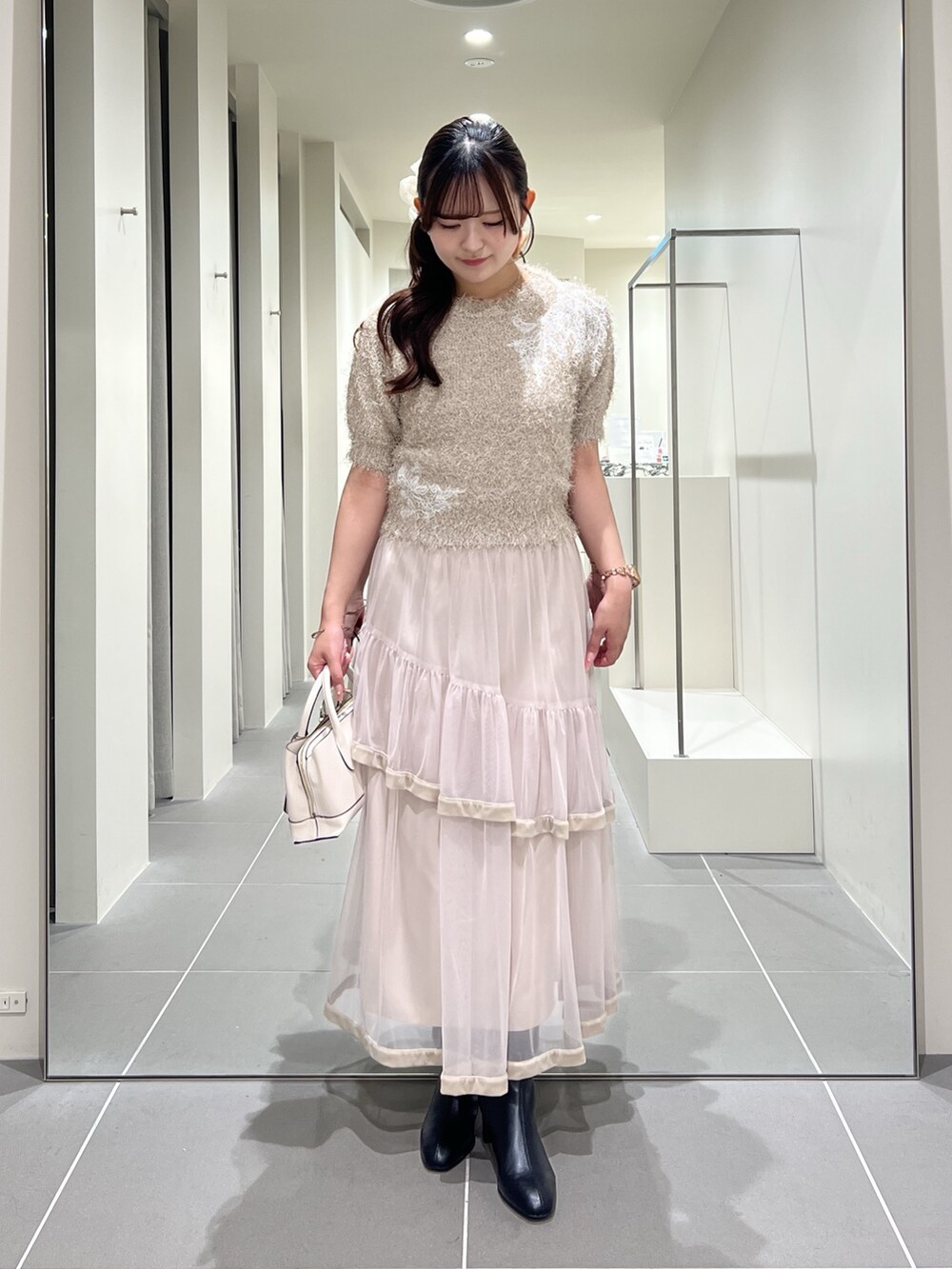 ベージュ系のニット/セーター、ベージュ系のスカート、ホワイト系のトートバッグを着用したレディースの夏コーディネートの6枚目の写真