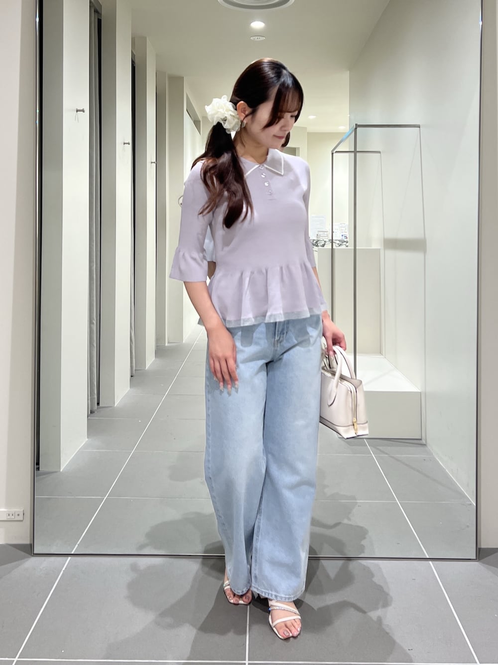 グレー系のニット/セーター、ブルー系のデニムパンツ、ホワイト系のトートバッグを着用したレディースの夏コーディネートの4枚目の写真