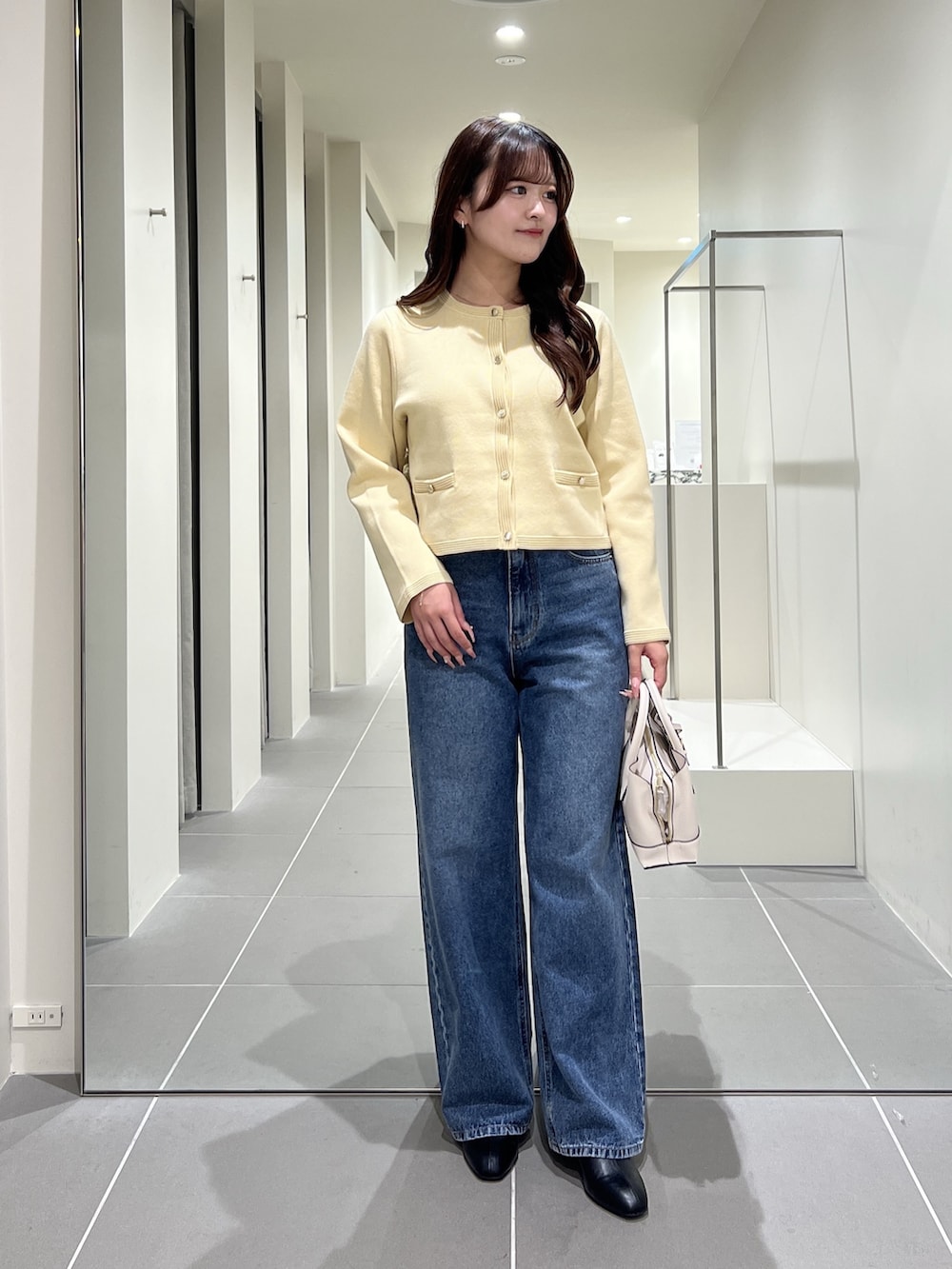 イエロー系のカーディガン/ボレロ、ブルー系のデニムパンツ、ホワイト系のトートバッグを着用したレディースの夏コーディネートの6枚目の写真